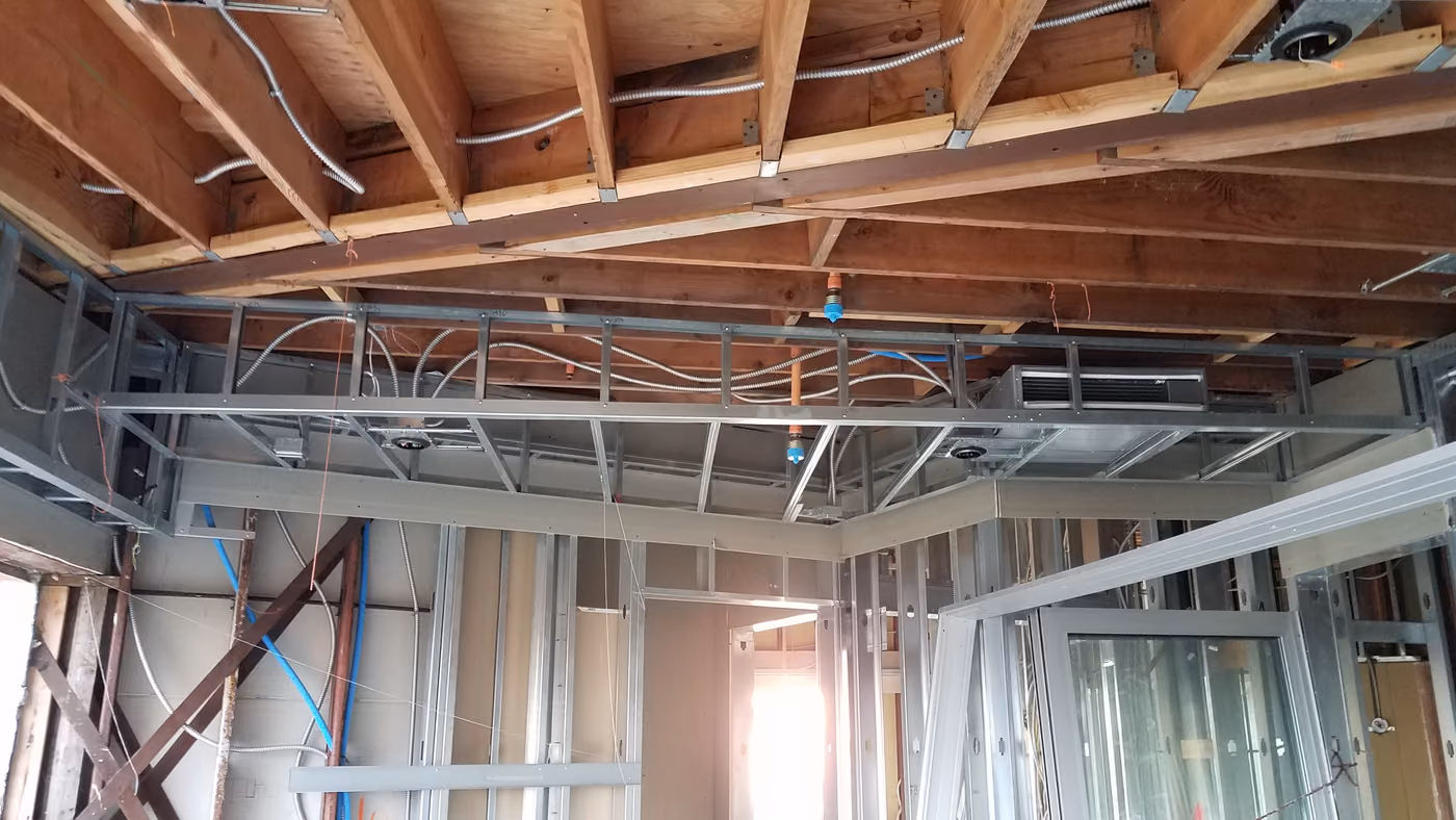 Exposed ceiling joists, ducting, and electrical runs mid-renovation